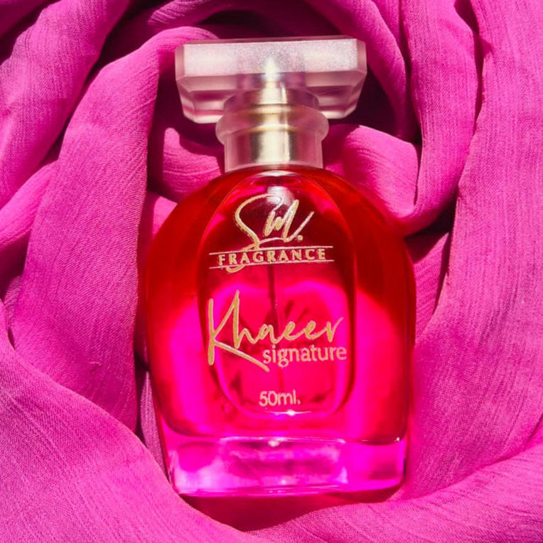 Perfume bottle with pink label inside a pink rose