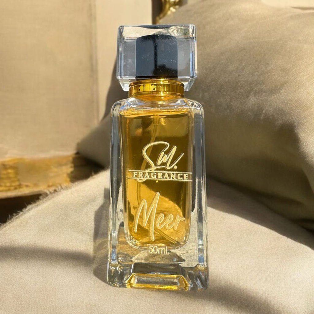 Perfume bottle labeled 'Stil Fragrance Meer' on a beige cushion with a decorative background